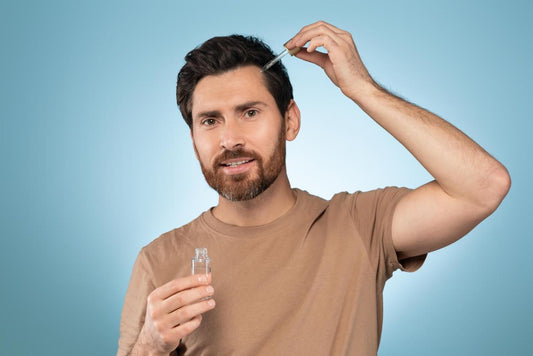 A man applying rosemary oil with a dropper to his scalp, demonstrating natural hair growth treatment and essential oil application for healthier hair. natural hair regrowth oil, rosemary essential oil benefits