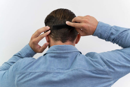 A man combing the back of his head, symbolizing hair loss linked to seborrheic dermatitis and scalp inflammation. seborrheic dermatitis hair loss, scalp inflammation, dandruff and hair fall
