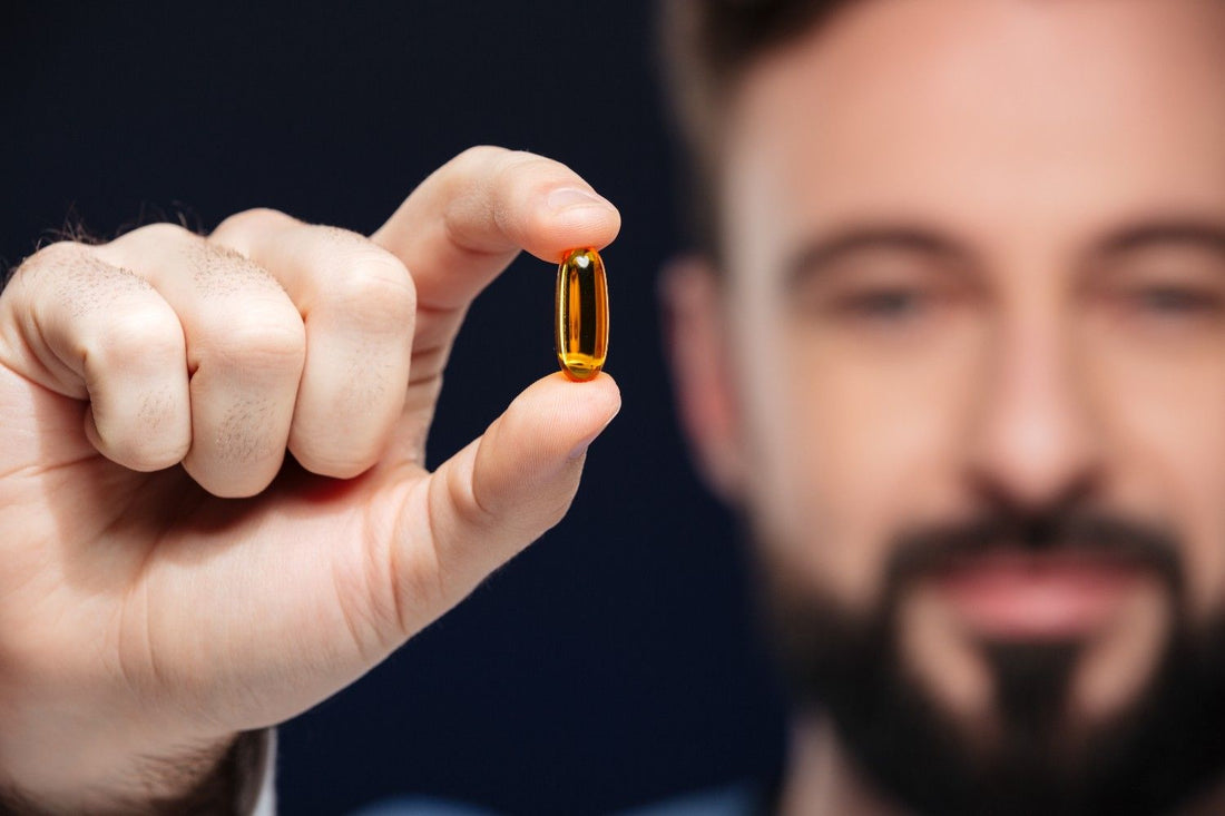 Man holding a vitamin capsule for hair regrowth and thickness