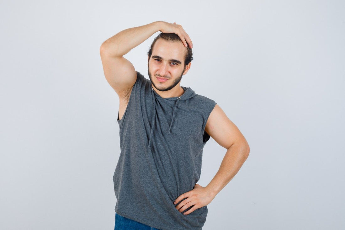 A young man touching his thinning scalp and smiling confidently, symbolizing transformation from thinning hair to thick hair. male hair growth journey, natural hair regrowth plan, scalp strengthening tips, biotin hair supplements,