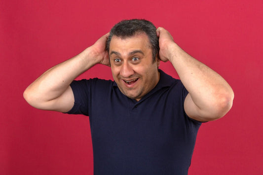 Man touching his scalp, symbolizing surprise and relief after reducing hair thinning causes and finding effective hair loss home remedies. pcos hair care, hormonal hair loss treatment, scalp health tips