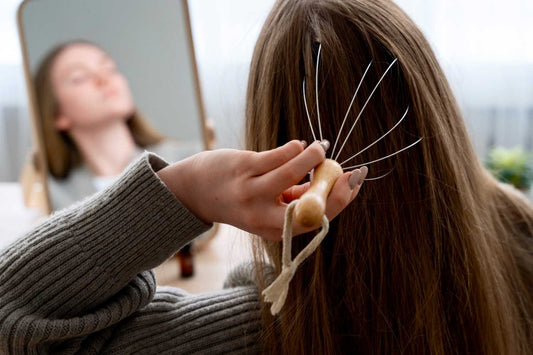 A woman using a scalp massage tool at home, representing hair care routines that support hair growth. stem cell hair research, scalp regeneration